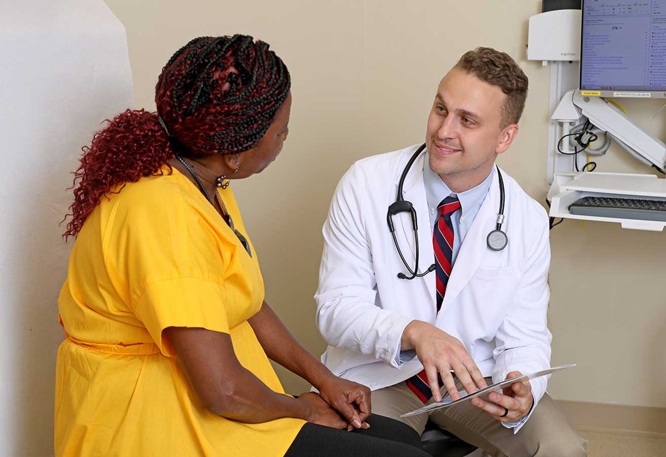 A urogynecologist reviewing a chart with a patient.